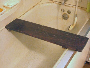 Wood board on bathtub for seating and reading/snacking