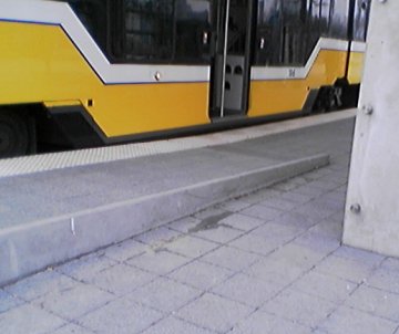 Raised entry ramp end with curb barrier showing alignment of level entry door above platform when train is stopped at high level platform.