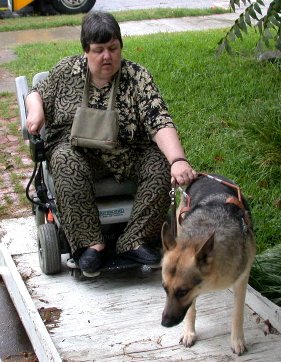 Suzanne with power chair and Caddo working up ramp.