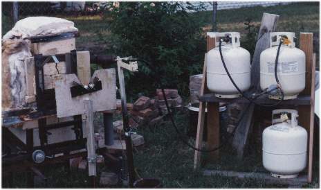 First furnace setup with manifolded propane tanks on stand.