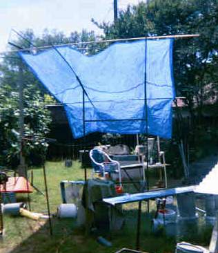 Welded sun shade set up with conduit supporting cheap blue tarp