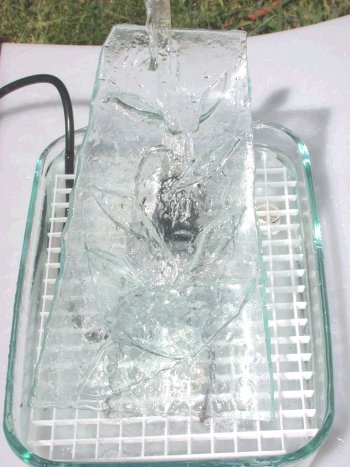 Glass tray  table fountain without rocks, with water, showing white grid.